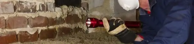 Pest control technician inspecting a crawl space for ant activity and entry points in Hollywood, FL
