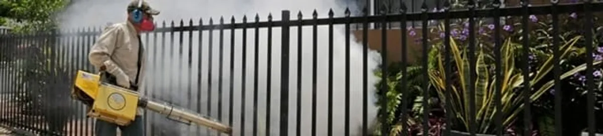 Mosquito control technician fogging a yard perimeter for mosquito reduction in Hollywood, FL